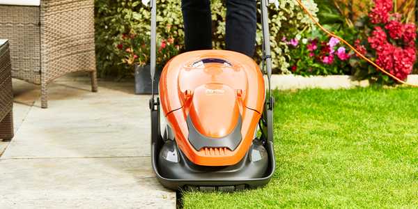 A man mowing a lawn using a Flymo® EasiGlide hover lawnmower.